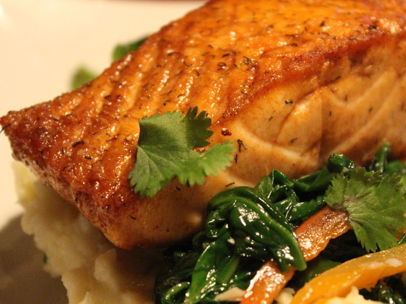 baked salmon on mashed potatoes with veggies