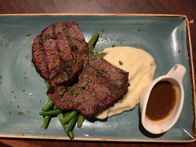 Parker's Restaurant and bar juicy steak on top of peas and gravy potatoes 