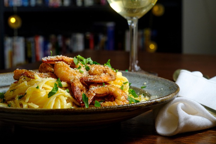 Cajun Alfredo dish with shrimp and wine
