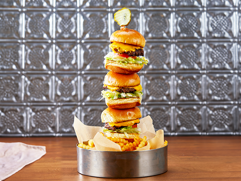 Granite City tower of burgers with a basket of crinkle cut fries
