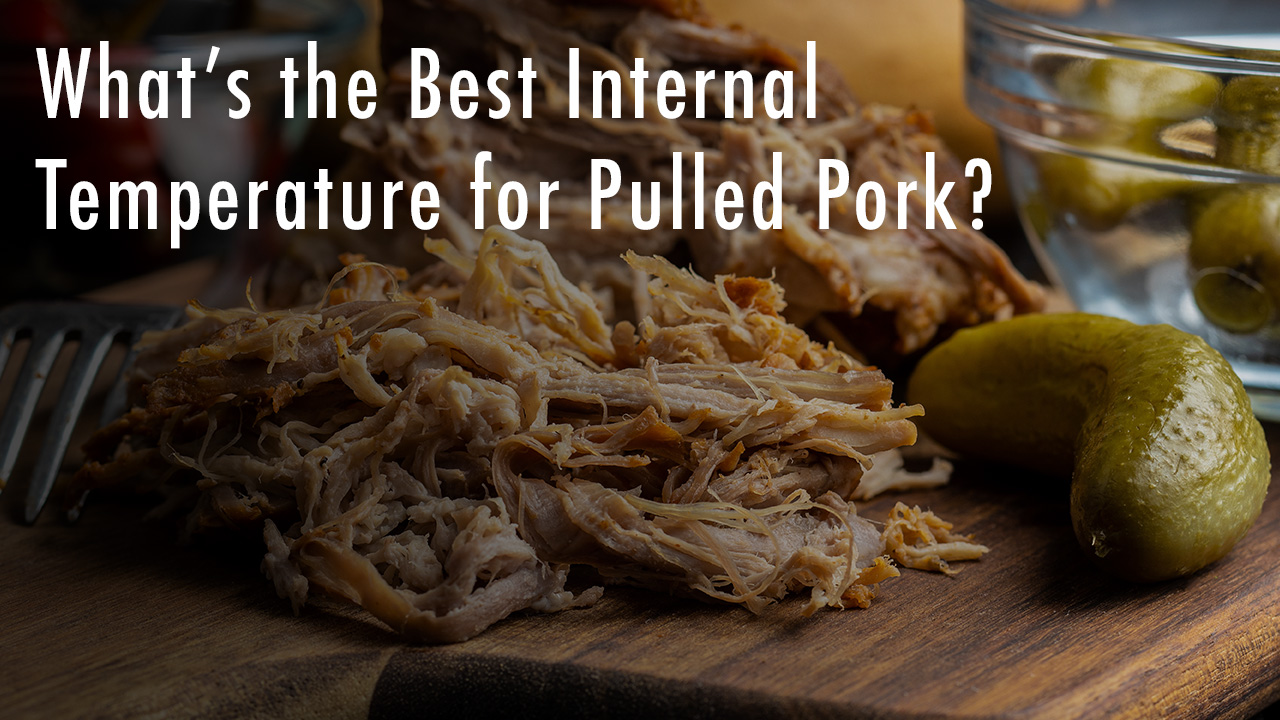 Shredded pulled pork on a wooden board with pickles and olives in the background, featuring text overlay that reads 'What’s the Best Internal Temperature for Pulled Pork?'